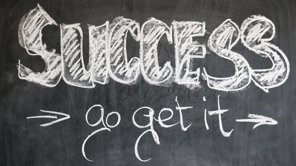 Blackboard with white chalk writing that says Success Go Get It