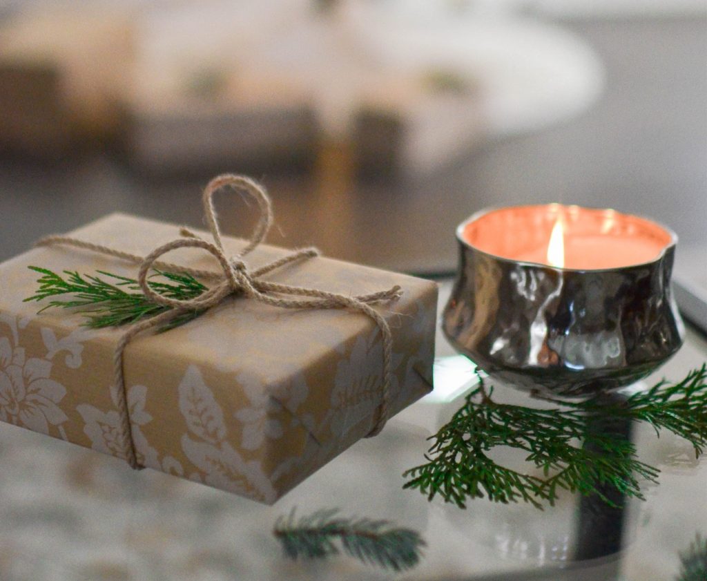 Close up of small holiday package with lit candle