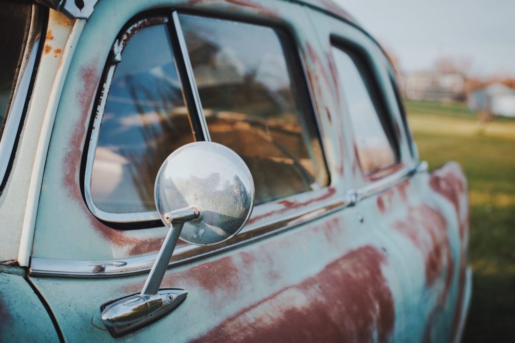 Close up of old turquoise and red colored car