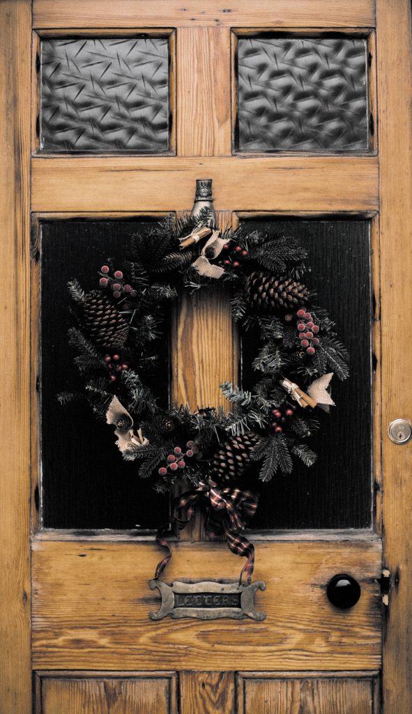 Close up of green wreath on old brown door