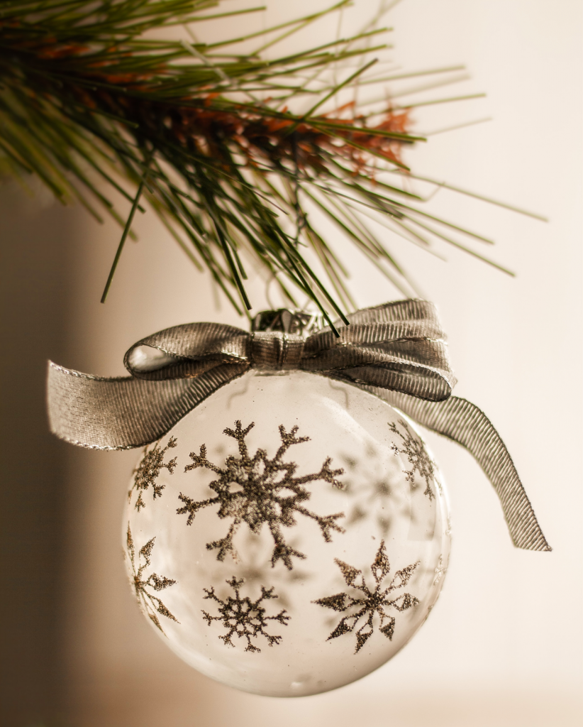 Close up of clear, snowflake ornament with silver ribbon