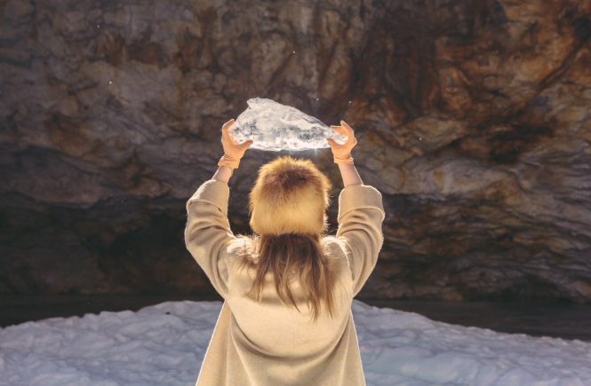 Woman holding block of ice up to sky.