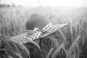 Straw hat in wheat field (black and white photo)