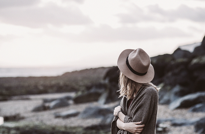 Woman wearing straw hat standing on beach