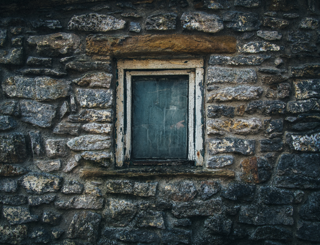 Stone wall with boarded up window