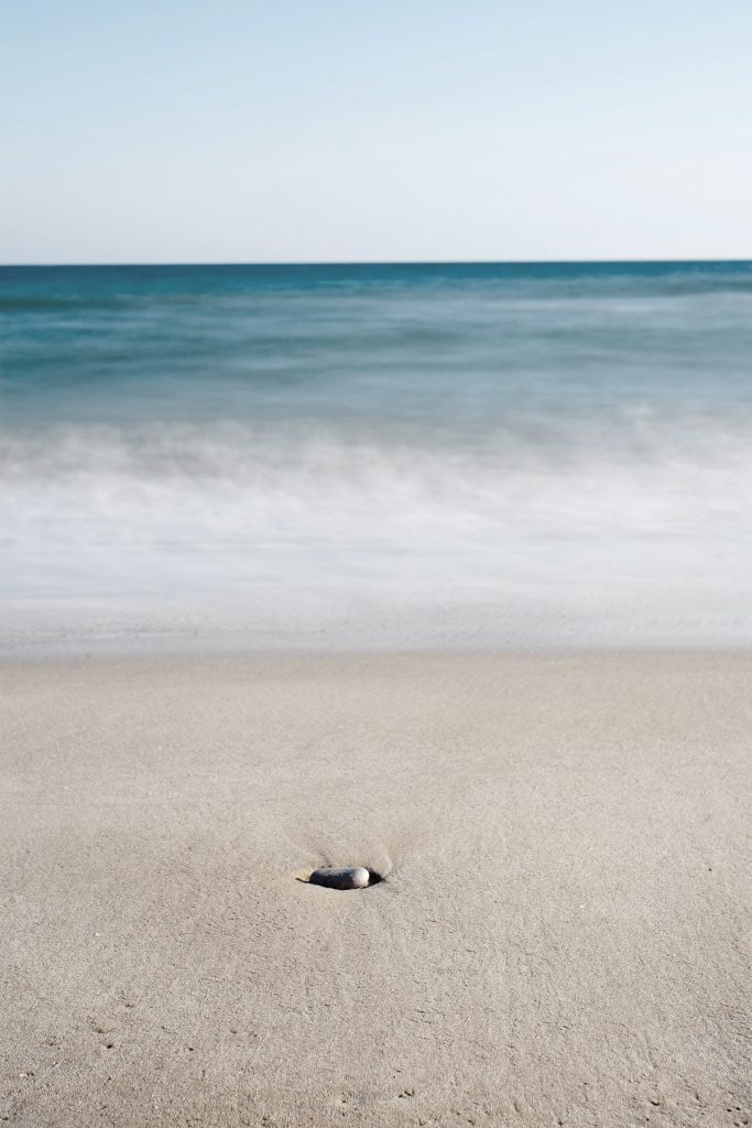 Ocean, sand, and one solo beach rock 