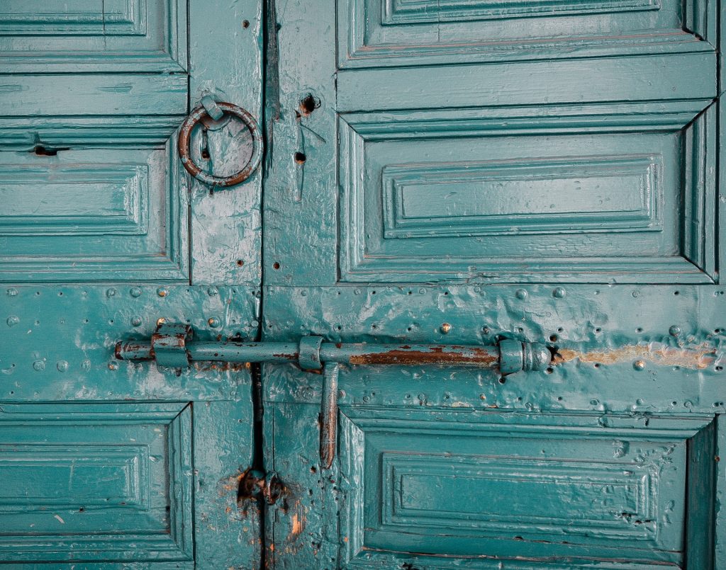 Turquoise colored wood door with bolt