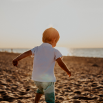 Small boy playing on beach with sunlight