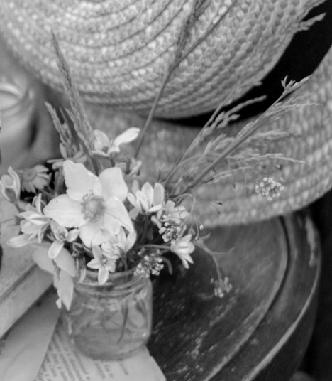 Straw hat and small bouquet flowers on wood chair