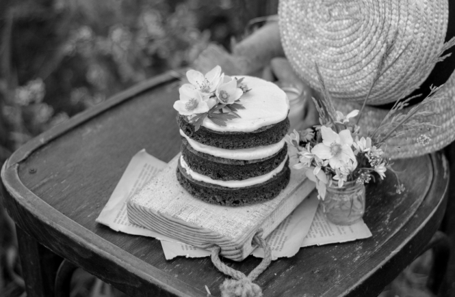 Cake, straw hat, small bouquet of flowers on chair